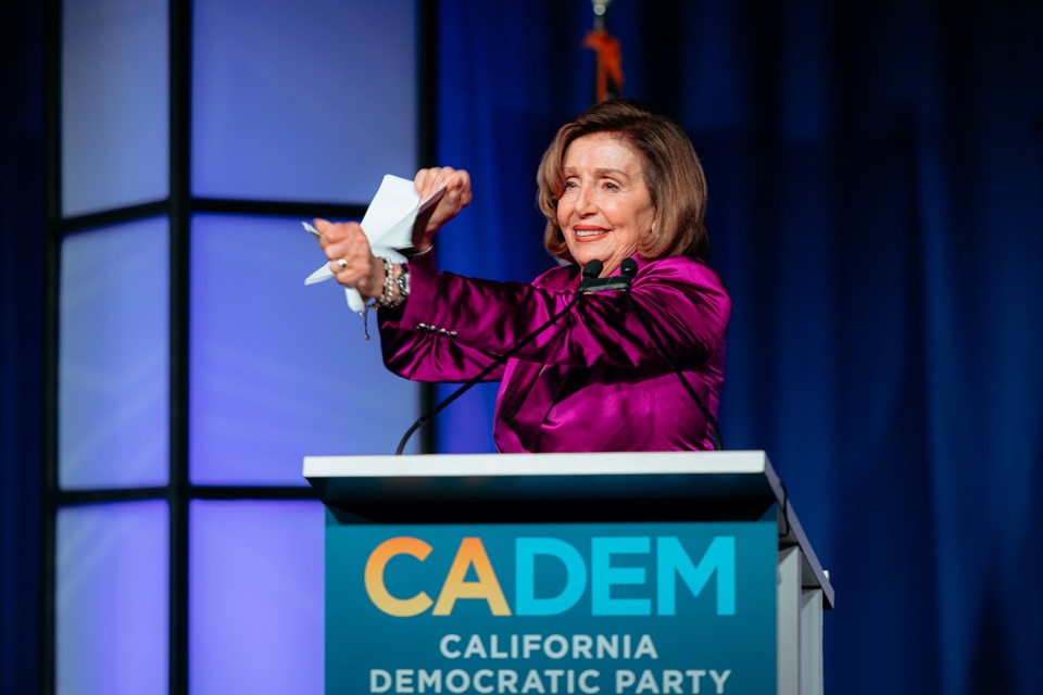 Speaker Emerita Nancy Pelosi gesturing at a podium during the CADEM convention